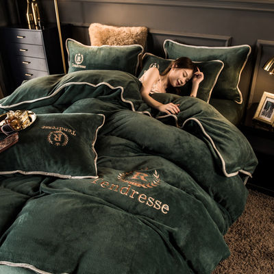 Un ensemble de lit en quatre pièces avec des broderies et des liens en peluche de lait