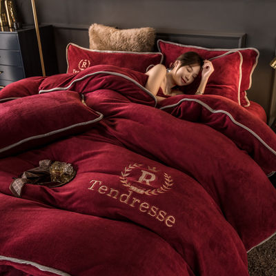 Un ensemble de lit en quatre pièces avec des broderies et des liens en peluche de lait