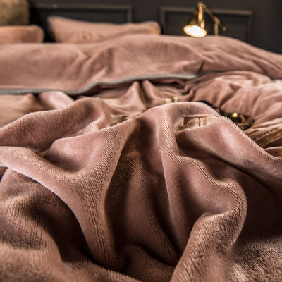 Un ensemble de lit en quatre pièces avec des broderies et des liens en peluche de lait