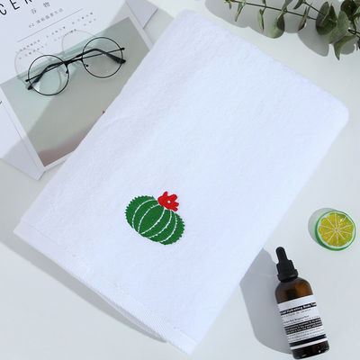 Une serviette de bain blanche douce et épaisse en coton pur avec une broderie personnalisée