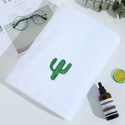 Une serviette de bain blanche douce et épaisse en coton pur avec une broderie personnalisée