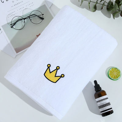 Une serviette de bain blanche douce et épaisse en coton pur avec une broderie personnalisée