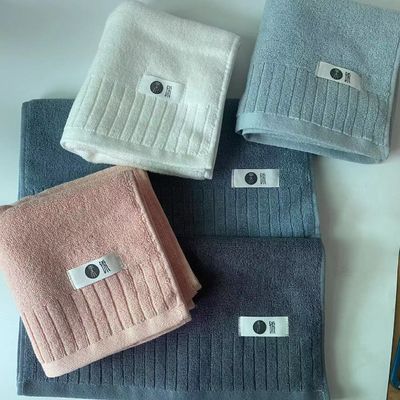 Une serviette de bain en coton douce et en peluche à double face, avec des fils extrêmes à rayures simples