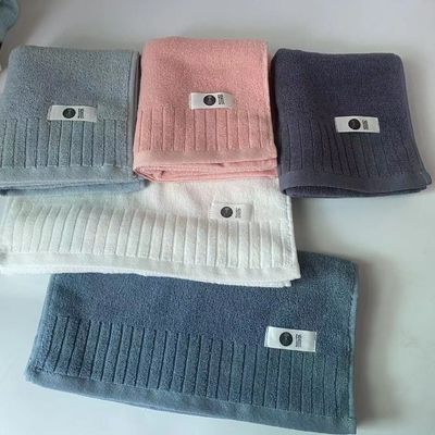 Une serviette de bain en coton douce et en peluche à double face, avec des fils extrêmes à rayures simples