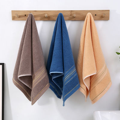 Une serviette en soie dorée sombre, douce et absorbante, idéale pour la maison.