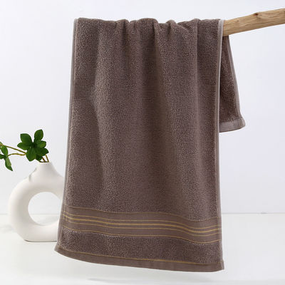 Une serviette en soie dorée sombre, douce et absorbante, idéale pour la maison.