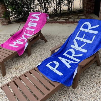 Une serviette de plage en microfibre personnalisée avec une police en gras et un nom personnalisé